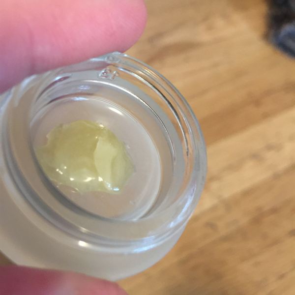 Small rosin chip in a glass jar held in the hand
